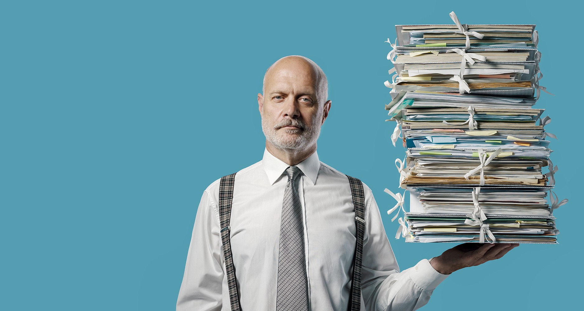 Confident businessman holding a pile of paperwork with one hand